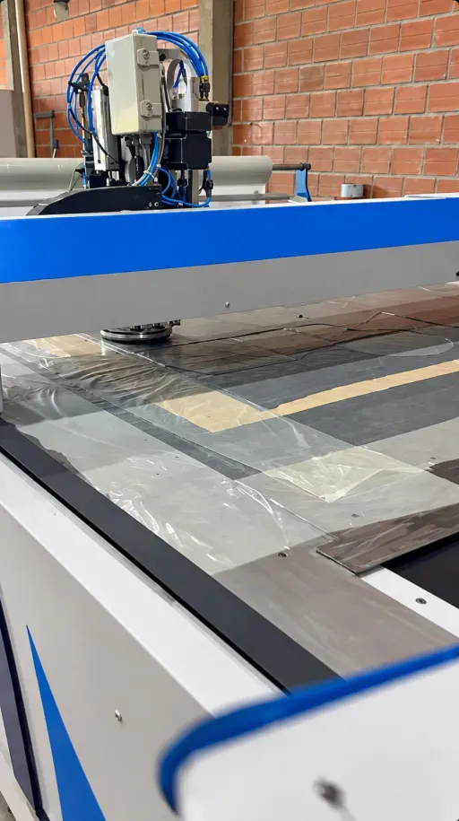 Mesa de corte automático com as camadas de tecido posicionadas